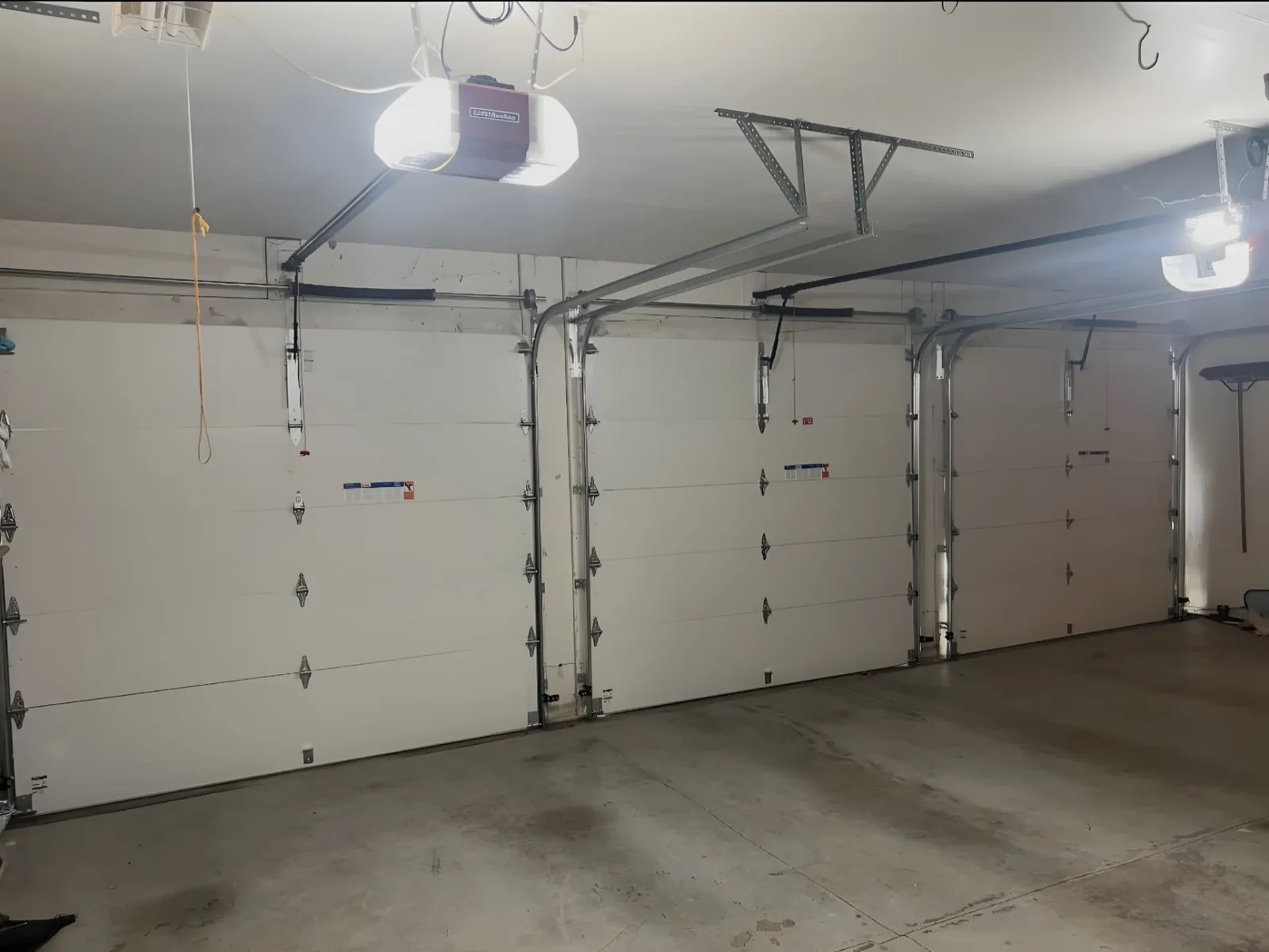 Interior view of three sectional garage doors with tracks and automatic openers