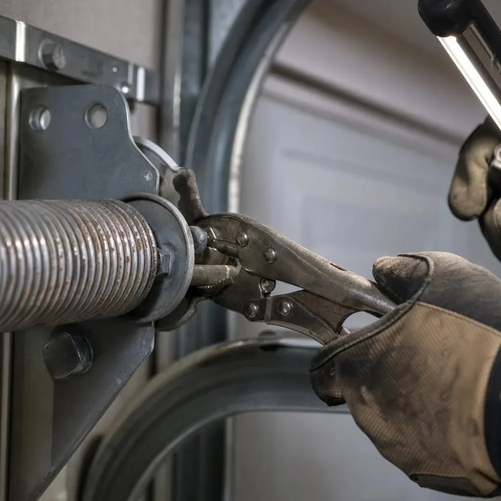 garage-door-torsion-spring-closeup-repair-philadelphia Close-up of hands securing a worn torsion spring during garage door repair