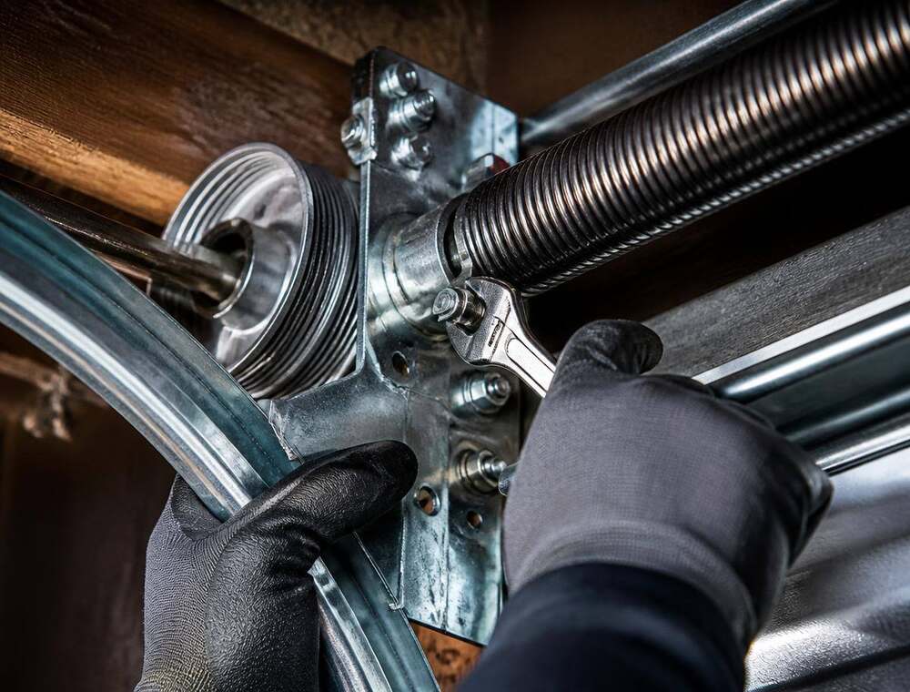 Technician performing remote opener programming work on garage door hardware
